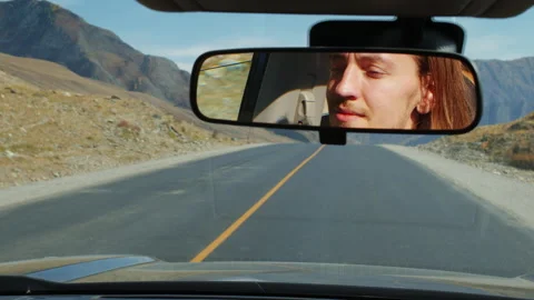 Man's face reflection in rearview mirror during road trip Stock-Footage 335215074