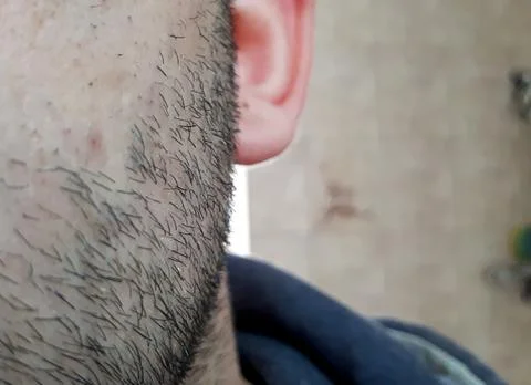 A man's face with a slight beard or stubble. A few days beard on the guy's ch Stock-Fotos