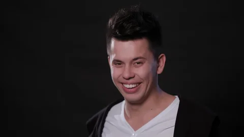 Man's Face Smiling Against a Black Background Stock Footage 87308473
