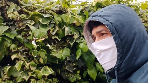 A man's face walking down the street wearing a mask Stock Footage 128975067