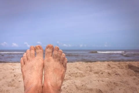Mans feet on the beach Stock Photos