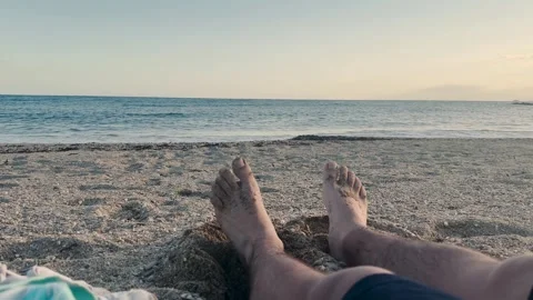 Man's feet moving on the sand while enjoying the Mediterranean Sea at sunset Video stock 346584118