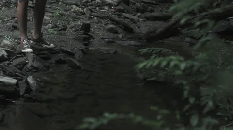 Mans feet by river in forest Video stock 27155595