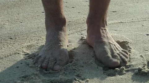 Man's feet in the send  Stock Footage 46083726