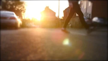 Mans feet walking over road at sunset in Britain  Stock Footage 85771076