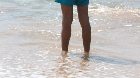 Man's feet washed by ocean waves and buries them in the sand. Point of view of Stock Footage 86232812