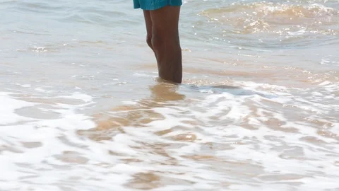 Man's feet washed by ocean waves and buries them in the sand. Point of view of Stock Footage 86232817