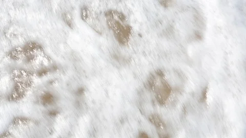 Man's feet washed by ocean waves and buries them in the sand. Point of view of Stock Footage 86233532
