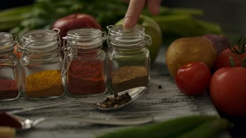 Man's finger choosing spices on kitchen table Stock Footage 121591791