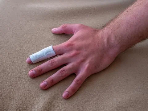 A man's finger covered with plaster on the damaged area. Stock Photos