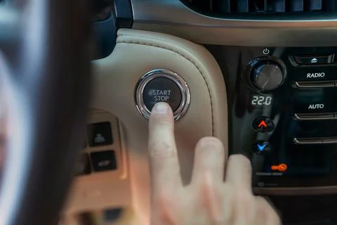 The man's finger pressing the start button. Using the push button to start an Stock Photos
