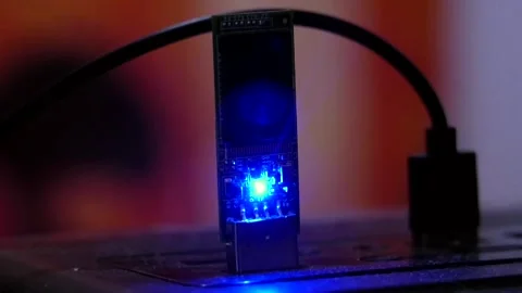 A man's fingers inserting a flash drive into a computer and pulling it back out. 動画素材 346881979