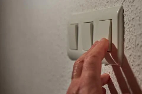 Man's fingers operating the light switch Stock Photos