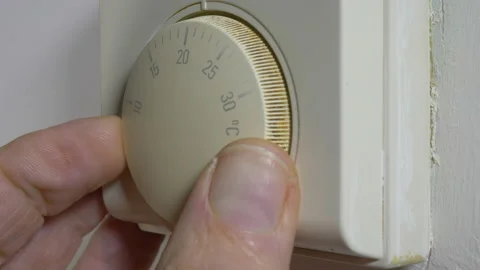 Man’s fingers setting the temperature on an old heating thermostat. Stock Footage 144544914