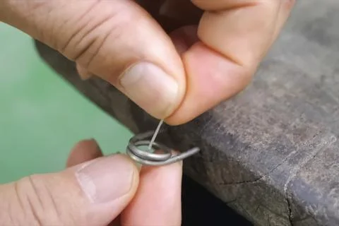Man's fingers thread through a ring fixed on the board. Stock Photos