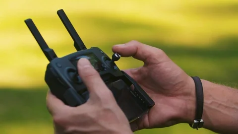 Man's fingers use the joysticks on a controller to fly a drone Stock Footage 91705328
