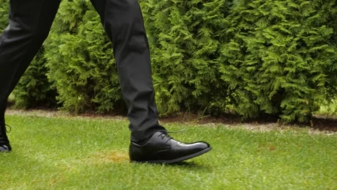 The man's footsteps tread upon the grass. Stock Footage 268190782