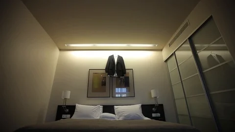 A man's glack jacket hanging in the bedroom hangs on a hanger before the groom's Vídeo Stock 93839902