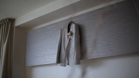 A man's glack jacket hanging in the bedroom hangs on a hanger before the groom's Stock Footage 95046491