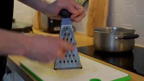The man's grating carrots on the kitchen table Stock Footage 129058657