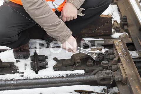 Man's hand with adjustable wrench at the railroad Stock Photos