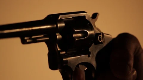Man's Hand Aims and Points a .45 Revolver in a dark room - Silhouette Stock Footage 106940792