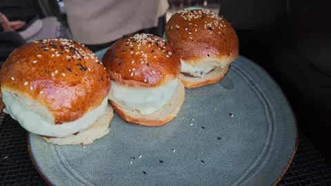 Man's Hand Assembling Cheeseburgers on Plate in Slow Motion Today Stock-Footage 343845430