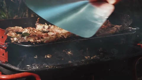 A man's hand blows up the fire on the grill. Movement of the hand from side to Stock Footage 143138319