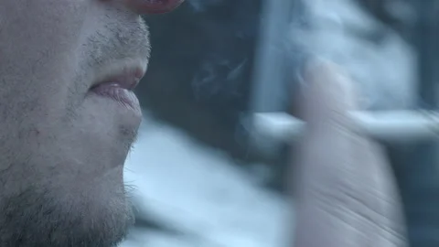 A man's hand brings a cigarette to his mouth. close-up Stock Footage 149726259