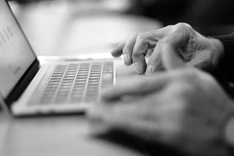 Man's hand brush on the notebook cursor control button while working with inf Stock Photos
