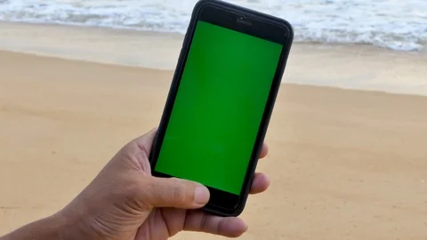 The man's hand caught the green screen phone on the beach Vídeo Stock 118998388