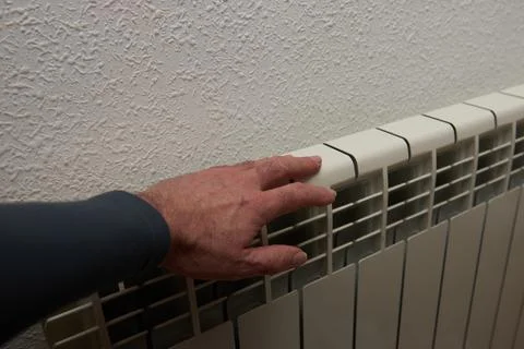 A man's hand checking the temperature of a radiator Stock Photos