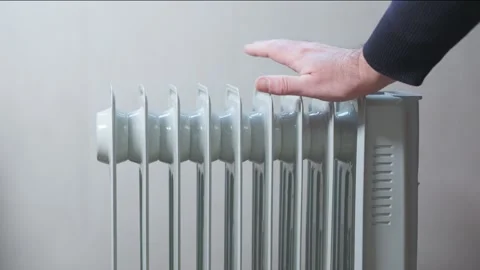 Man's hand checks temperature of electric heating radiator. Stock Footage 256087534