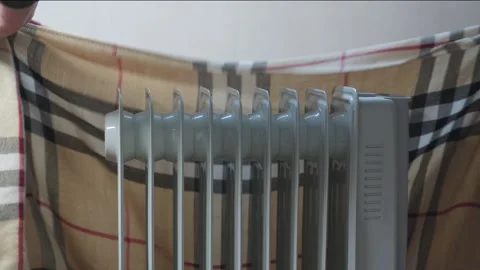 Man's hand checks temperature of heating radiator and then wraps it in blan.. Stock Footage 255431120