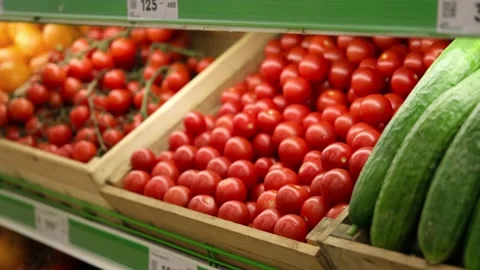 A man's hand chooses a tomato on a store shelf. Stock Footage 208335176