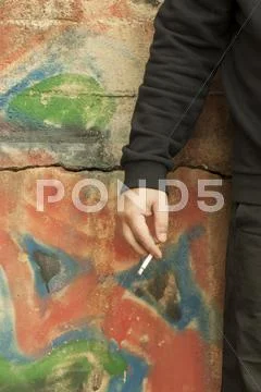 Man's hand with a cigarette on the graffiti wall Stock Photos
