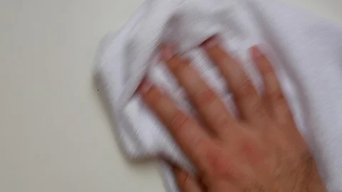 A man's hand cleans a white surface with a white cloth Stock Footage 124166223