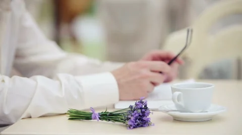 Man's hand with a close up of a cup and a bouquet of lavender. Stock-Footage 52129199