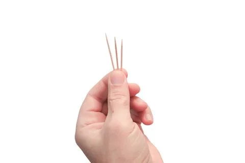 A man's hand with close-up toothpicks. Three sharp wooden sticks in his hand. Stock Photos