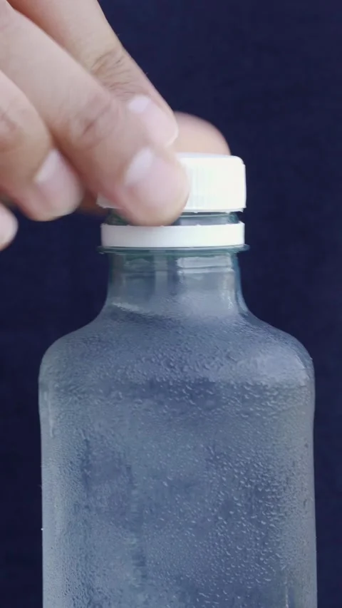 A man's hand closing the cap of a plastic bottle 库存影片 337033653