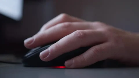 Man's hand on a computer mouse, works in the evening behind the monitor, evening Stock Footage 154011701