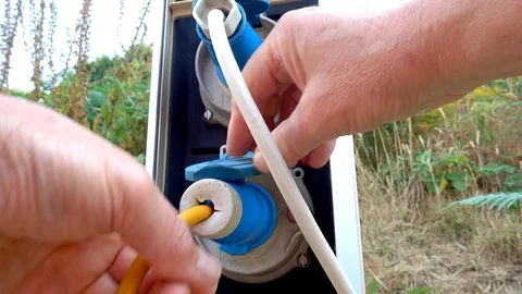 Man’s hand connecting power cable to a campsite supply. Stock Footage 93089142
