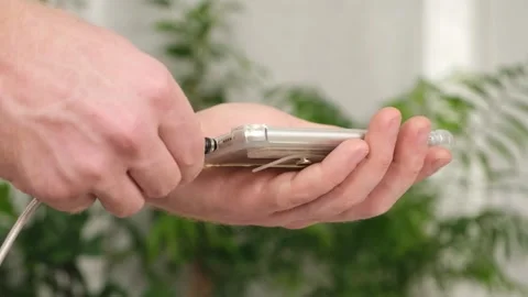 Man's hand connects magnetic cable for charging smartphone Stock Footage 242298567