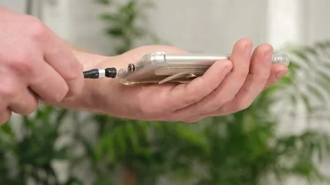Man's hand connects magnetic cable for charging smartphone Stock Footage 242444258