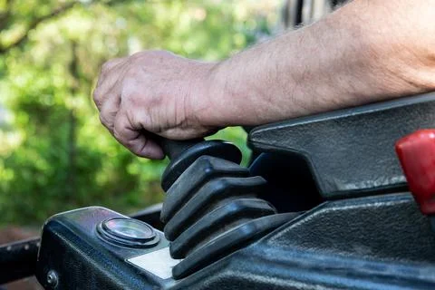 Man's hand on the control lever of a mini excavator Stock Photos