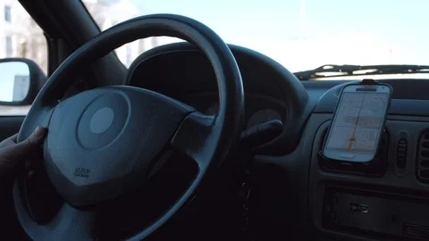 The man's hand controls the car. driver use smartphone as gps navigator. Stock Footage 101684801