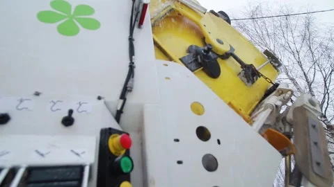 A man's hand controls a garbage truck that lifts container with waste in winter Stockbeeldmateriaal 246714493