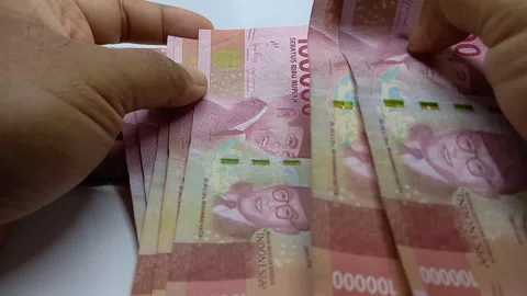 A man's hand is counting and checking Indonesian banknotes Stock Footage