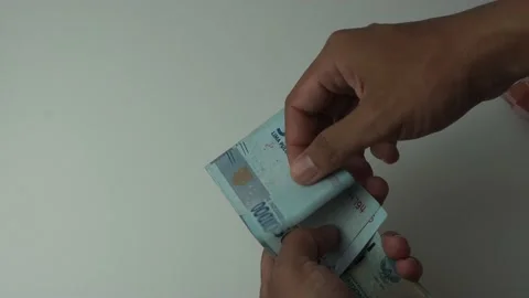 Man's hand counting fifty thousand rupiah bills, indonesian money on a white  Stock Footage 222279720