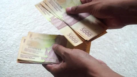 Man's hand counting five thousand rupiah banknotes Video stock 304402374